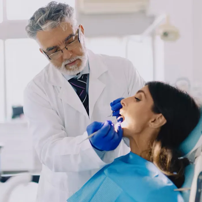 Clinician examining a patient during an oral pathology exam
